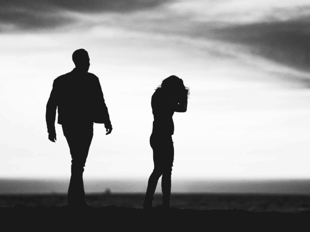 Twee personen in silhouetten. Een vrouw staat met haar rug naar een man toe.