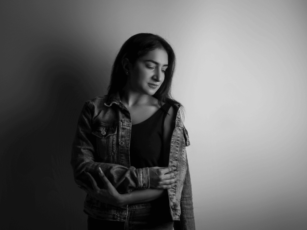 Woman smiling, against a wall. Black and white image